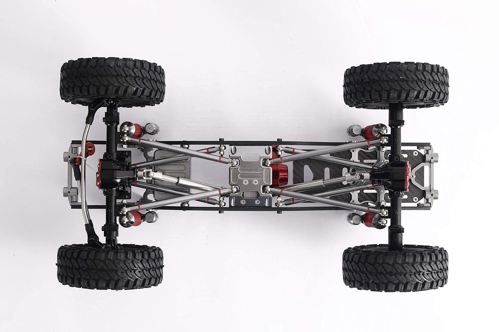 Top-down view of a 4WD remote control truck chassis with four black off-road tires, silver metal suspension arms, and red mechanical components on a white background.