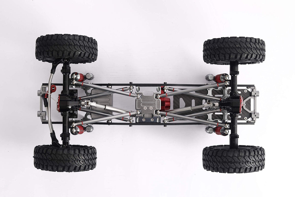 Top-down view of a 4WD remote control truck chassis with four black off-road tires, silver metal suspension arms, and red mechanical components on a white background.