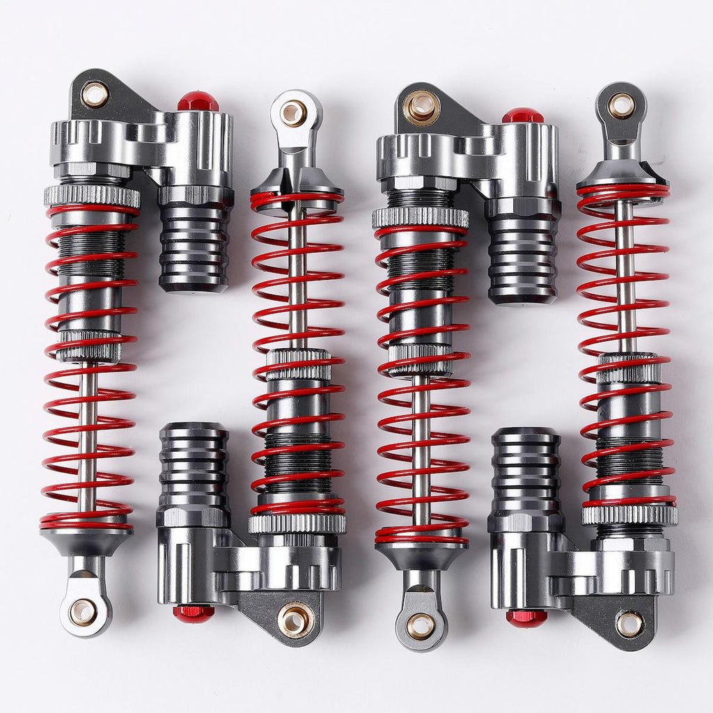 Four pairs of silver metal shock absorbers with bright red springs, arranged in two rows on a clean white background.