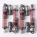 Four pairs of silver metal shock absorbers with bright red springs, arranged in two rows on a clean white background.